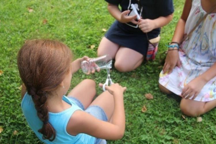 Eine Teilnehmerin schneidet eine PET-Flasche auf.