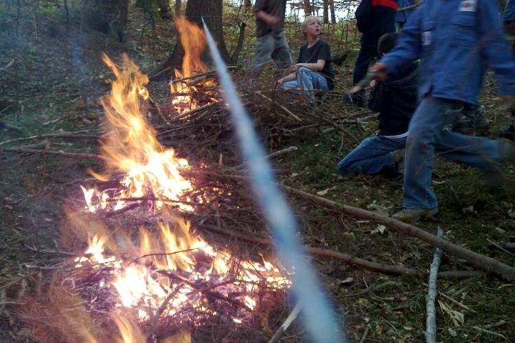 Ein Team sammelt Reisig und Brennholz, während ein anderes Feuer bereits brennt.